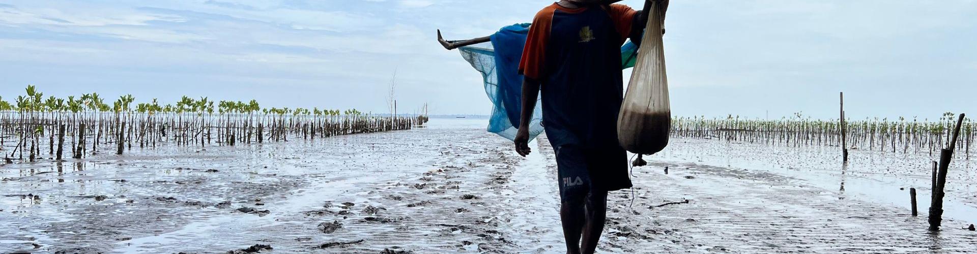 Mann läuft im flachen Wasser