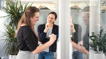 Two women in office laughing