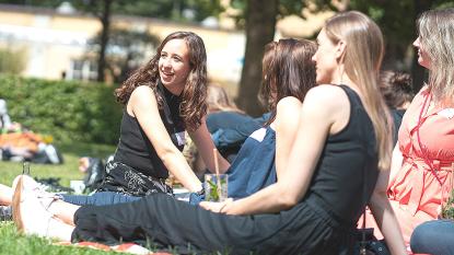 people sitting in gras and laughing