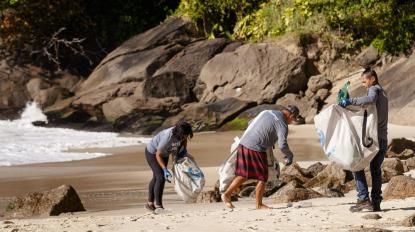 People collect plastic on a beach